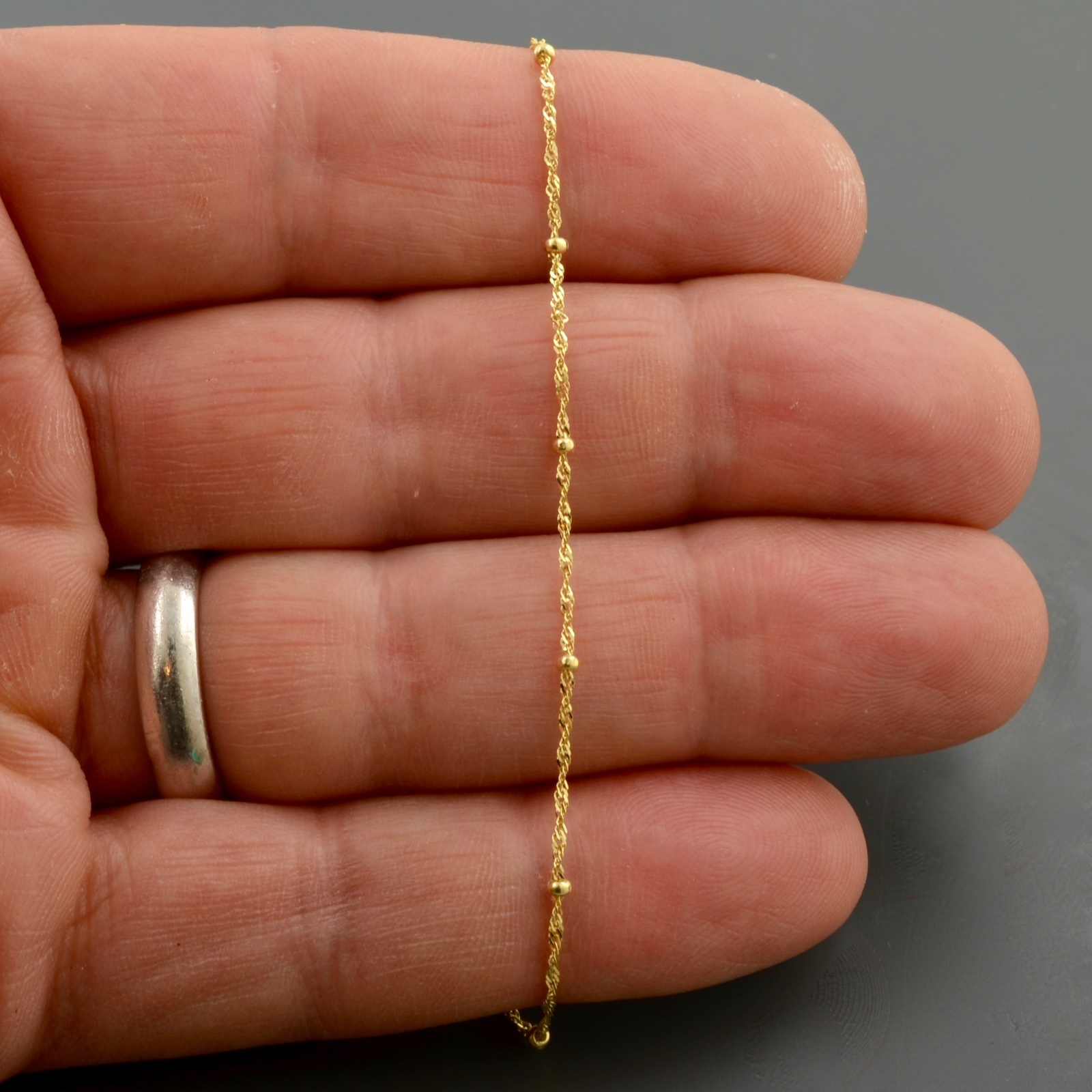 10K YELLOW GOLD 1.0MM SINGAPORE SATURN CHAIN W/1.9MM BEAD STATIONS