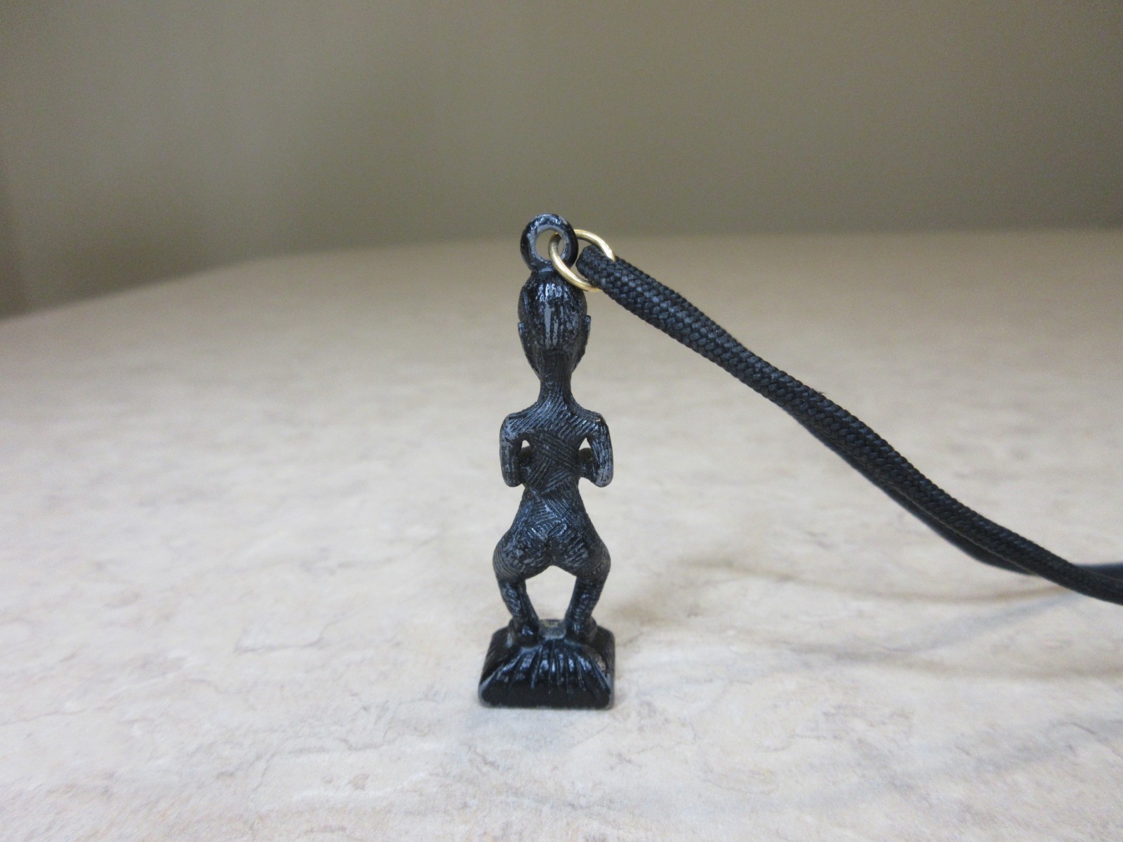 Vintage Metal Tiki Figurine Pendant From Polynesia. Black with green gem eye