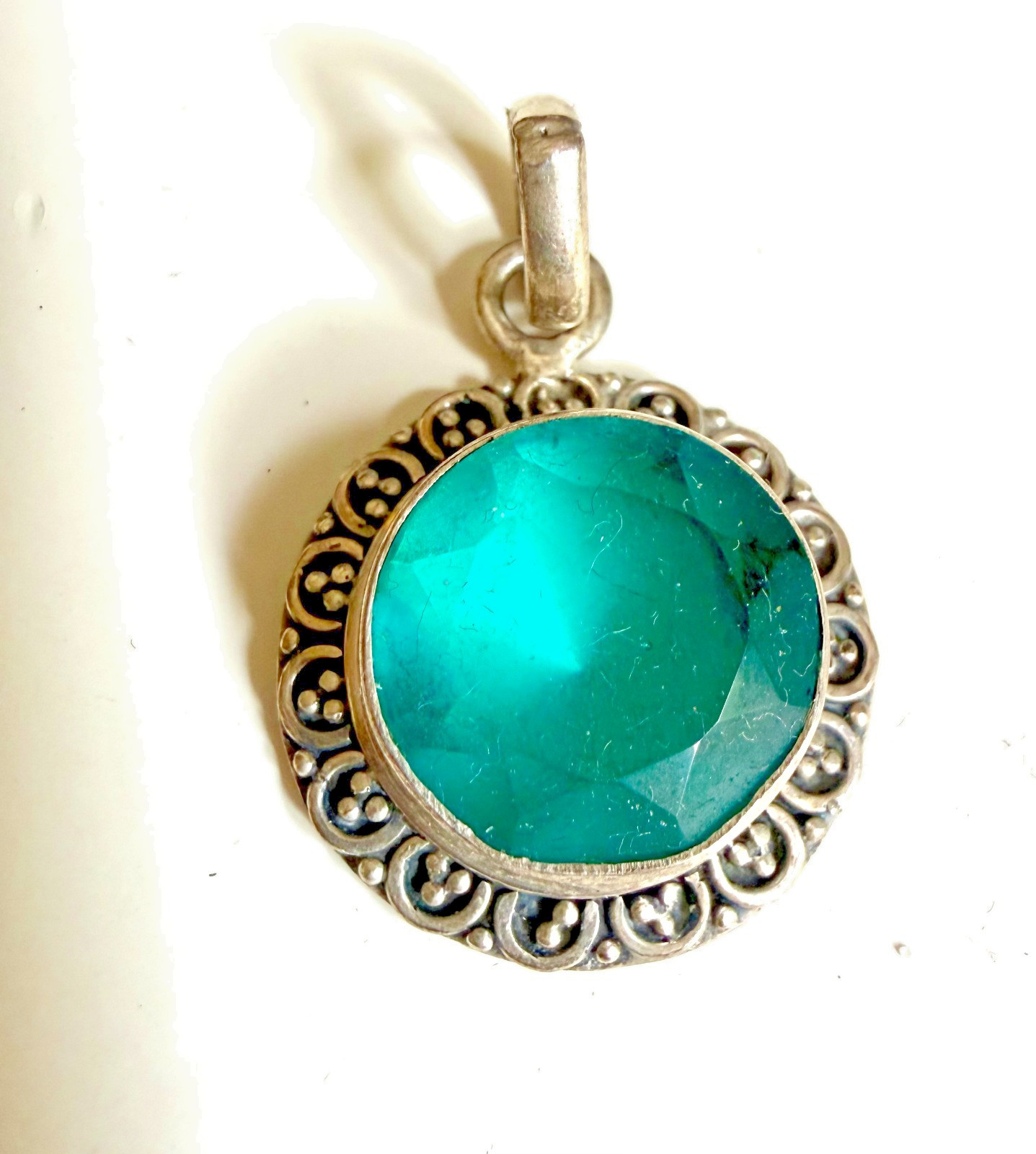 terling silver pendant featuring a faceted aquamarine blue gemstone in decorati