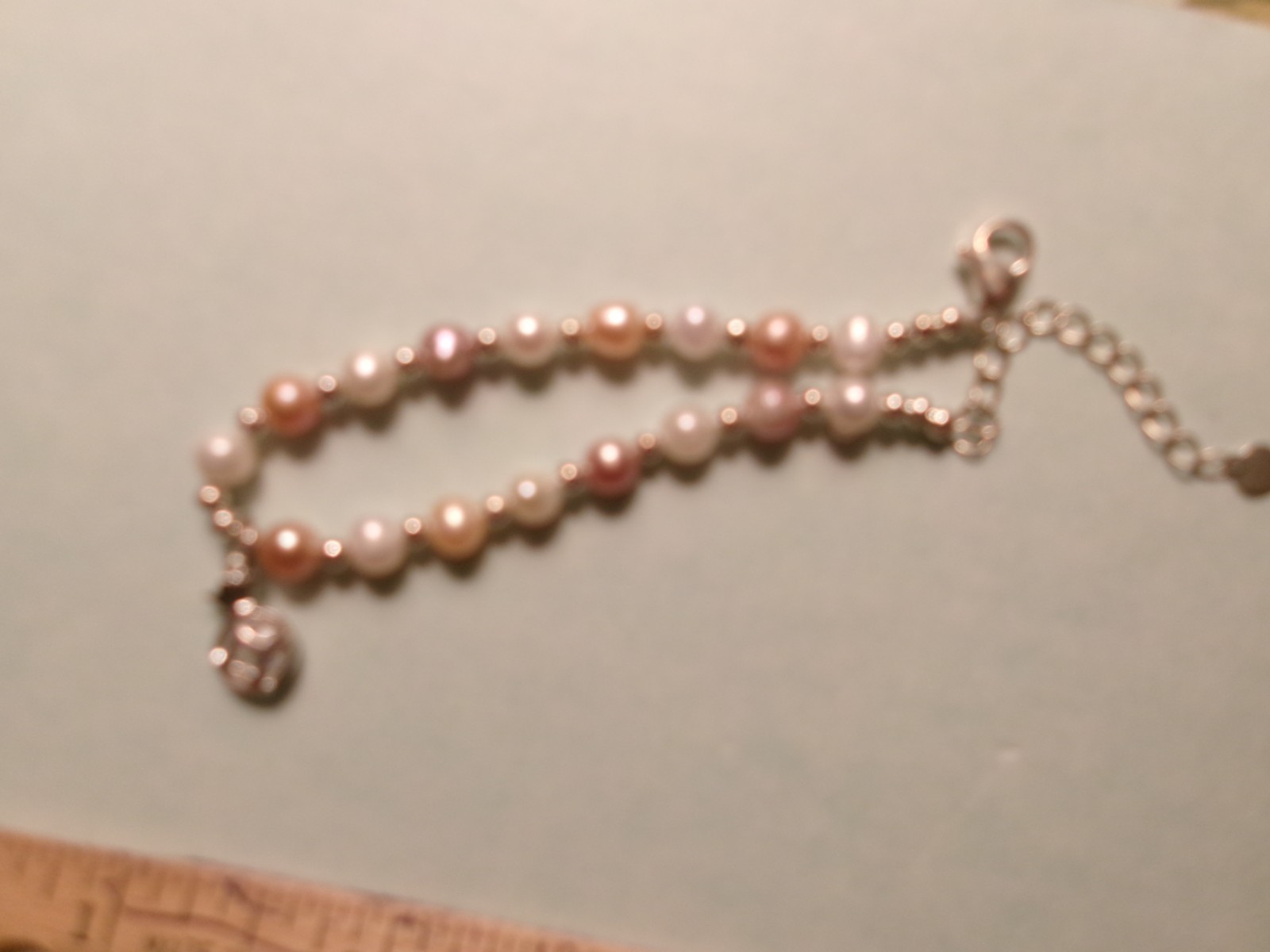PEARL BRACELET HAS A GLASS DIAMOND IN A CAGE