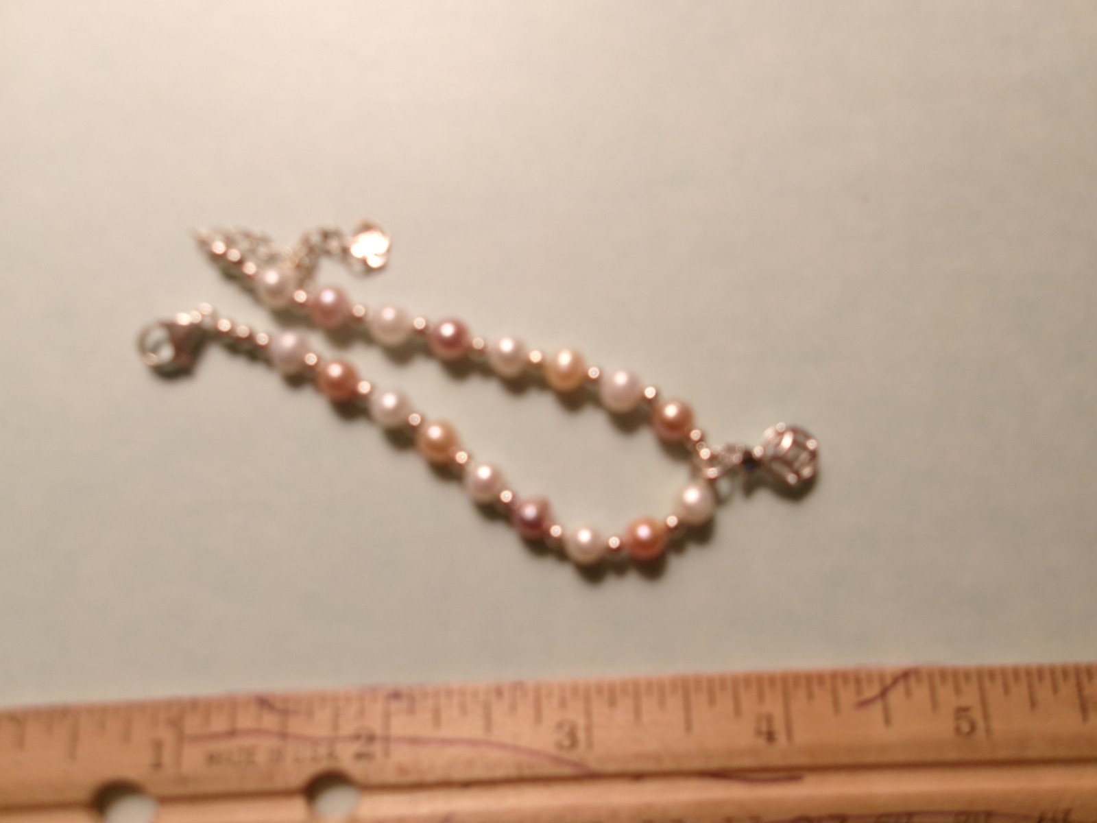 PEARL BRACELET HAS A GLASS DIAMOND IN A CAGE