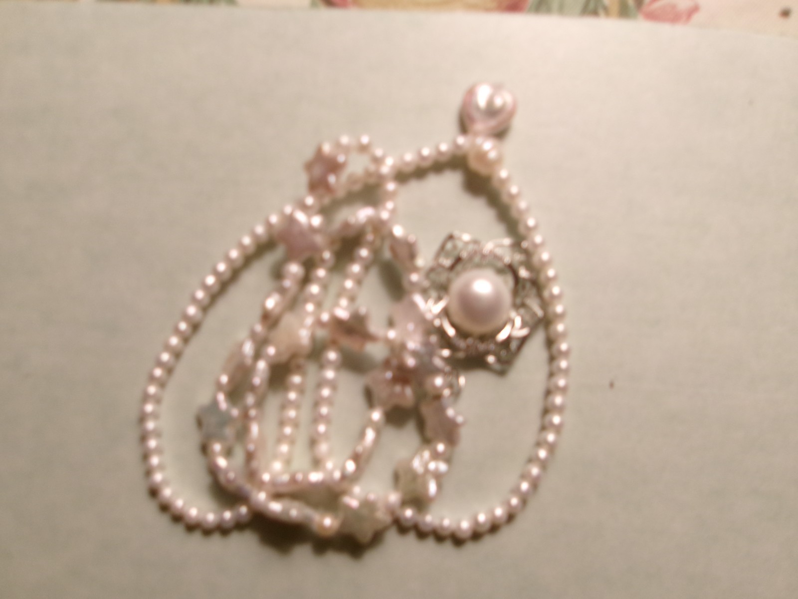 PEARL NECKLACE WITH STARS SLIPS OVER HEADSIZE 12 MM ON CENTER PEARL