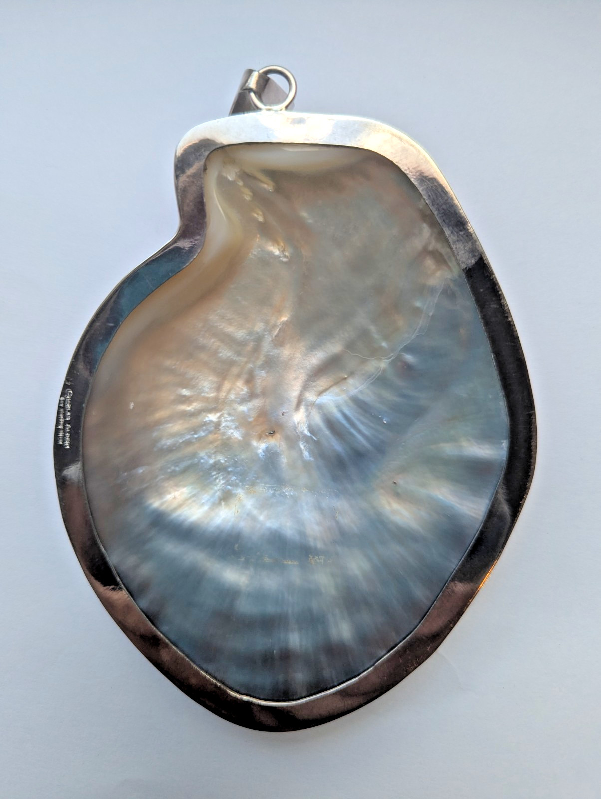 Charles Albert Irridescent black pearl shell pendant framed in simple silver set