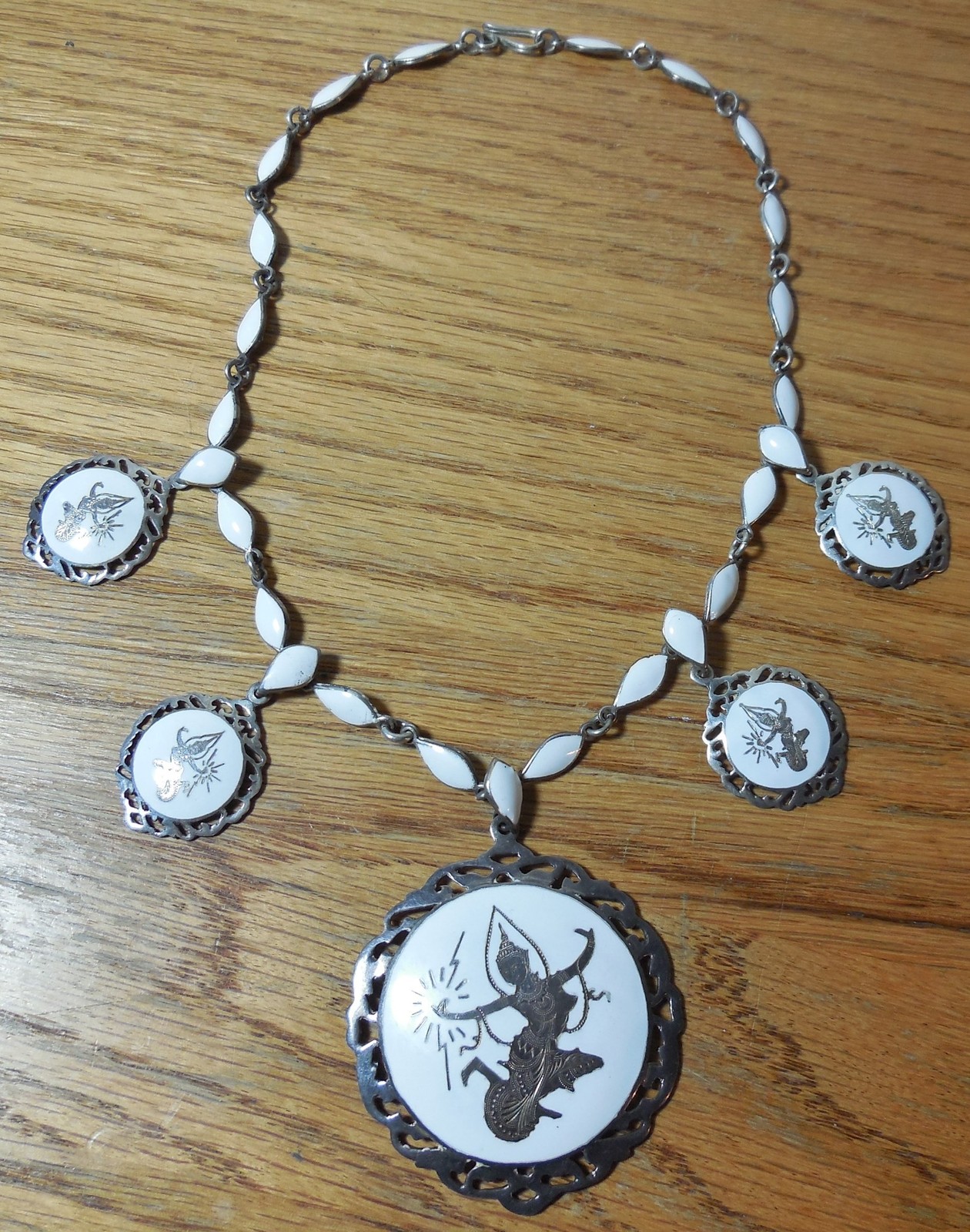 A VINTAGE SIAM WHITE ENAMEL STERLING SILVER NECKLACE WITH DANCER PENDANTS