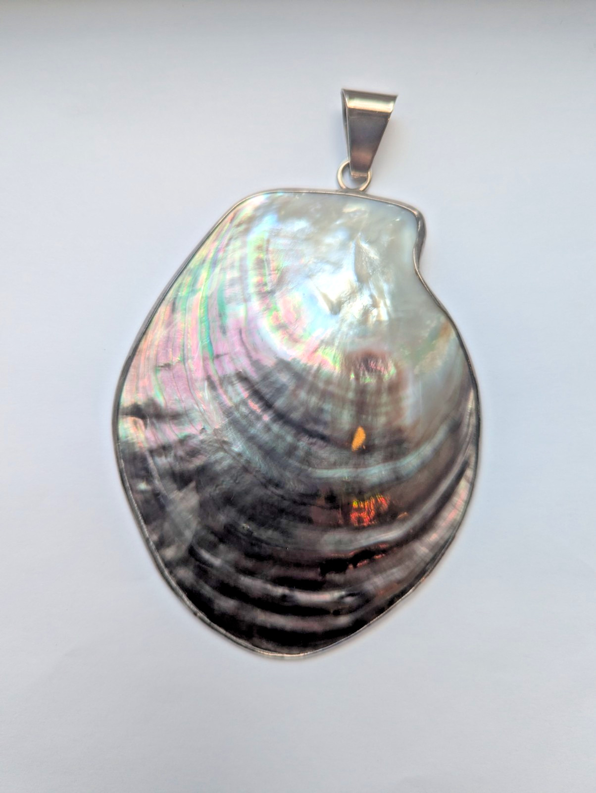 Charles Albert Irridescent black pearl shell pendant framed in simple silver set