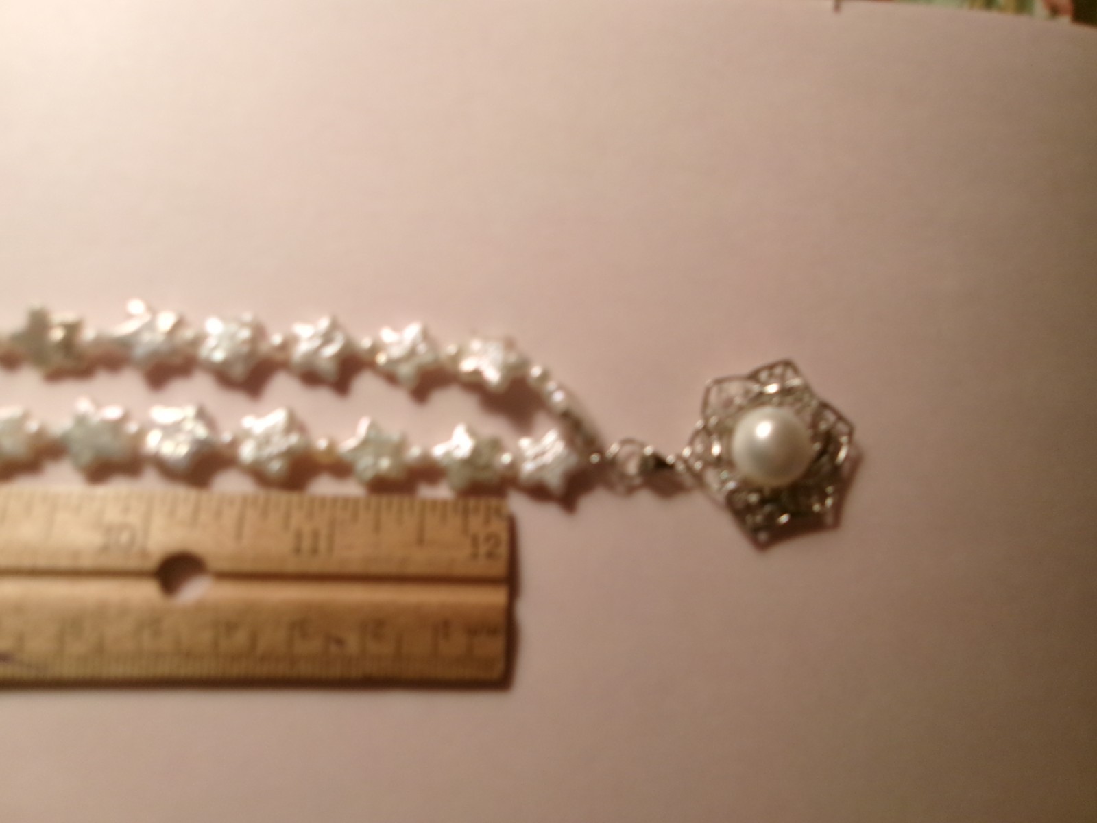 PEARL NECKLACE WITH STARS SLIPS OVER HEADSIZE 12 MM ON CENTER PEARL
