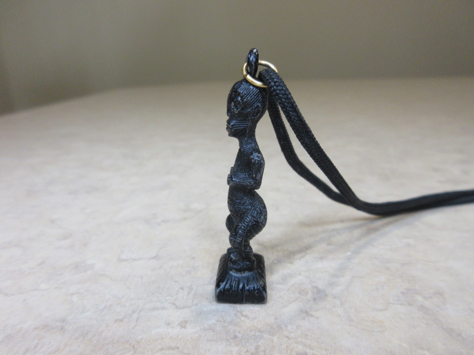 Vintage Metal Tiki Figurine Pendant From Polynesia. Black with green gem eye