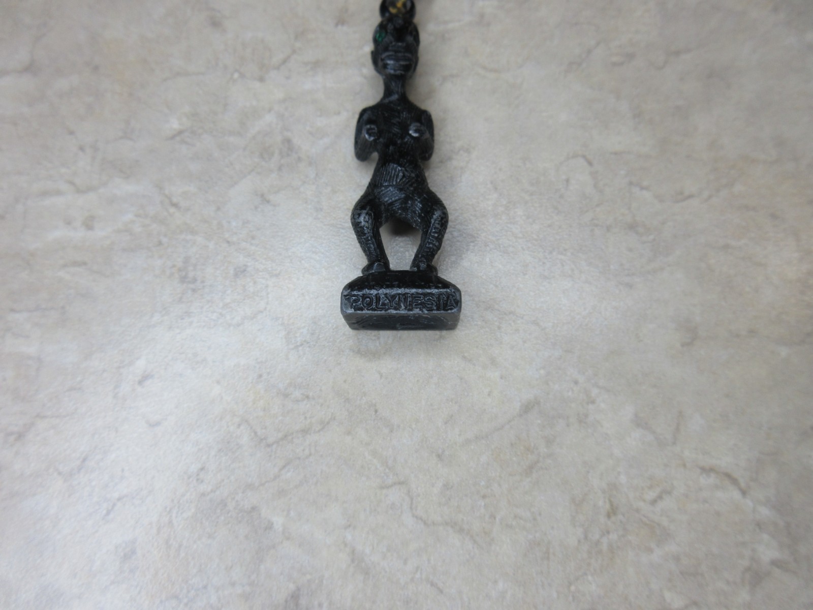 Vintage Metal Tiki Figurine Pendant From Polynesia. Black with green gem eye